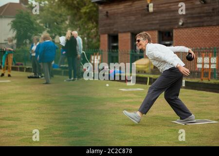 Eine Seitenansicht Schuss eine aufgeregte ältere Frau, die ihre Aufnahme in ein Spiel der Lawn Bowling. Stockfoto