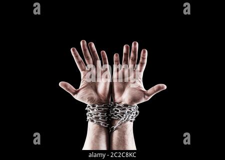 Zwei Hände in Ketten auf schwarzen Hintergrund mit Freistellungspfad isoliert Stockfoto