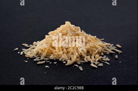 Geriebenen Parmesan auf schwarzem Hintergrund Stockfoto