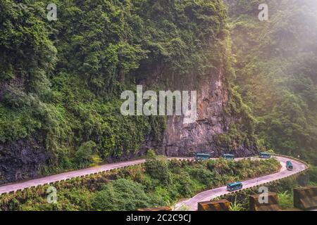 Busse mit Touristen auf die kurvenreiche Straße von 99 wendet sich an die Spitze der Tianmen Mountain, Zhangjiajie Nationalpark, Hunan, China Stockfoto