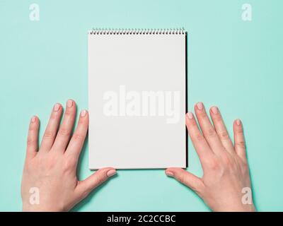 Leeres Papier Notizbuch und weibliche Hände Stockfoto