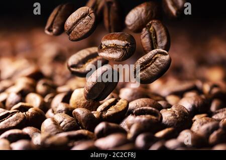 Kaffeebohnen fallen auf Haufen Stockfoto