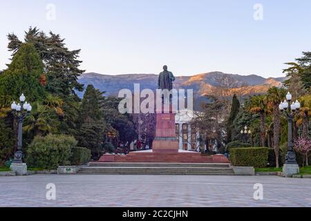 Lenin-Denkmal in Jalta bei Sonnenuntergang, Grünfläche und Bergblick im Hintergrund, Krim Stockfoto