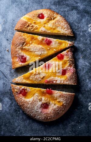 Blick von oben auf einige Stücke einer Coca de Sant Joan, eine typische süße flache Kuchen aus Katalonien, Spanien, gegessen an Saint Johns Eve, auf einer grauen Stein Brandung Stockfoto