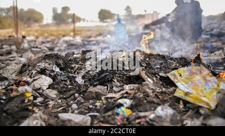 Brennender Müll und armer alter indischer Mann. Stockfoto