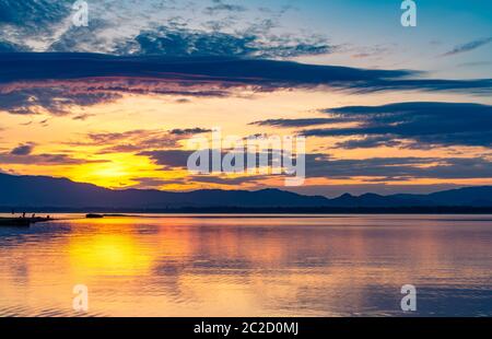 Schönen goldenen Himmel am Morgen mit Sonnenaufgang über Berge und See oder Fluss. Landschaft von Behälter und Berg. Friedlich, ruhig und tranqu Stockfoto