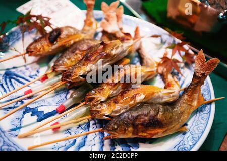 Gegrillte Fische auf Sticks als Street Food an Nishiki Markt in Kyoto, Japan. Stockfoto