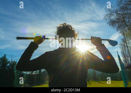Golfer Leaning ihren Golfclub auf ihren Schultern mit Sonnenlicht. Stockfoto
