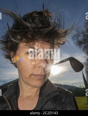 Golfer Leaning ihren Golfclub auf ihren Schultern mit Sonnenlicht. Stockfoto