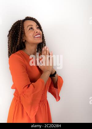 Vertikales Porträt einer lächelnden afroamerikanischen Frau, die betet Stockfoto