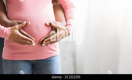 Nahaufnahme von afrikanischen schwangeren Paar, die Hände auf Frau Bauch Stockfoto