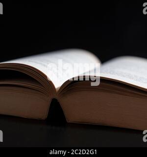 Ein offenes Buch bei schwachem Licht Stockfoto