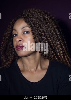 Vertikales Porträt einer afroamerikanischen Frau, die die Kamera anschaut Stockfoto