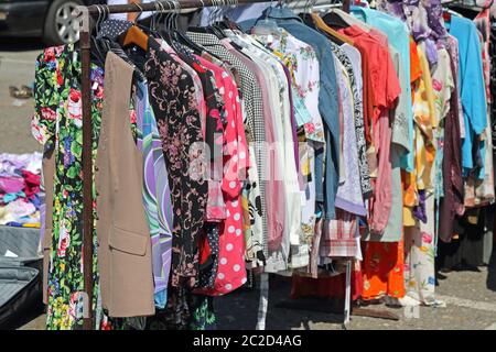 Second Hand Kleidung aufhängen auf Schienen auf Flohmarkt Stockfoto