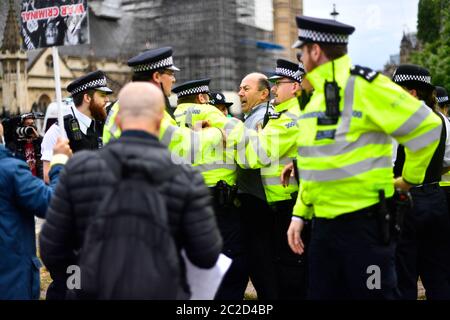 Die Polizei verhaftete einen Mann (Mitte), nachdem er vor dem Auto von Premierminister Boris Johnson rannte, als es das Parlamentsgebäude, Westminster, verließ. Der Mann, der über die Operation der Türkei gegen kurdische Rebellen im Nordirak demonstriert hatte, wurde von Offizieren in den Palast von Westminster gebracht. Stockfoto