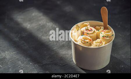Gerolltes Eis in Kegelbecher auf dunkel, kopieren Raum Stockfoto