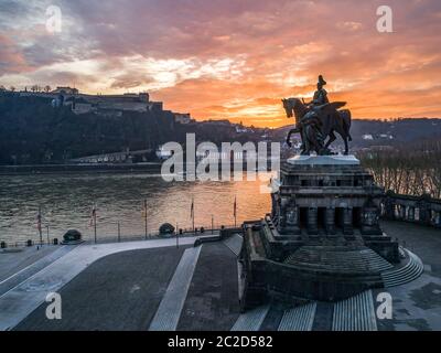 Bunte Sonnenaufgang brennender Himmel Stadt Deutschland historisches Denkmal Deutsche Ecke, wo die Flüsse rhein und Mosel zusammenfließen Stockfoto