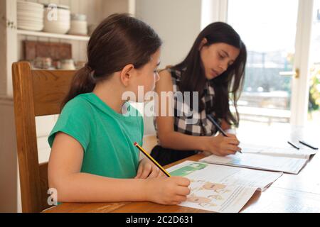 Zwei Mädchen zu Hause Schulbildung aus der Küche Tisch Stockfoto