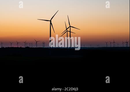 Schwarze Silhouette von Windenergieanlagen Energie generator auf eine erstaunliche Sonnenuntergang an einem Windpark in Deutschland Stockfoto