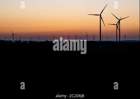 Schwarze Silhouette von Windenergieanlagen Energie generator auf eine erstaunliche Sonnenuntergang an einem Windpark in Deutschland Stockfoto