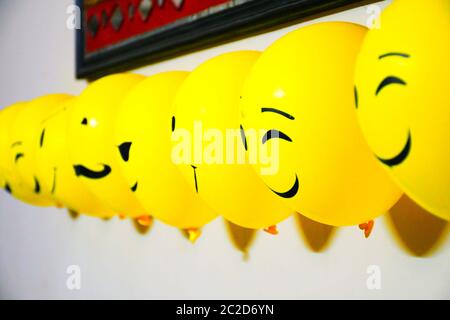 Luftballons Dekoration an der Wand, Emoji Gesichter auf Luftballons Stockfoto