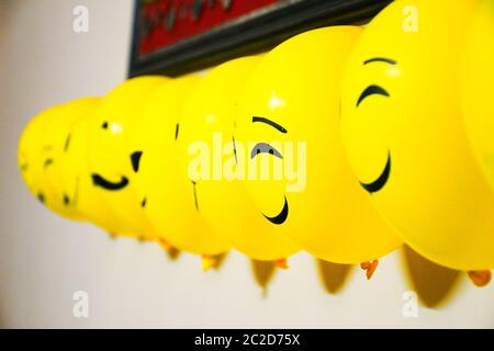 Luftballons Dekoration an der Wand, Emoji Gesichter auf Luftballons Stockfoto