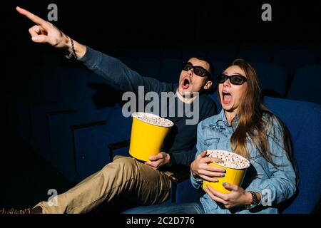 Kino Tag, junges Paar mit Popcorn suchen Horrorfilm im Kino. Stockfoto