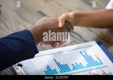 Geschäft Leute die Hände schütteln über Gewinne Chart Stockfoto