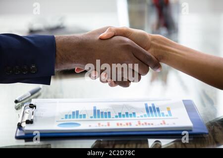 Geschäft Leute die Hände schütteln über Gewinne Chart Stockfoto