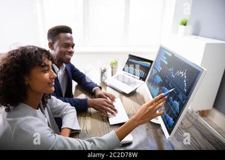 Börse Broker Analyse Diagramme auf dem Computer im Büro Stockfoto