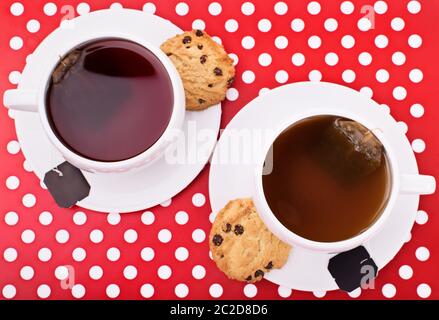 Nahaufnahme von oben aus zwei Tassen Tee mit Schokoladenkeksen auf einer Platte. Stockfoto