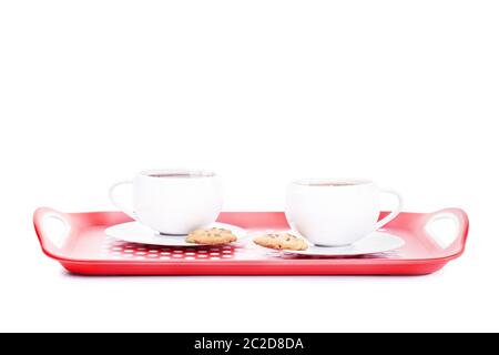 Zwei Tassen Tee mit Keksen auf einer Schüssel auf weißem Hintergrund. Stockfoto