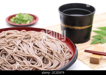 Japanische Zaru Soba Nudeln auf Holzplatte auf weißem Hintergrund Stockfoto