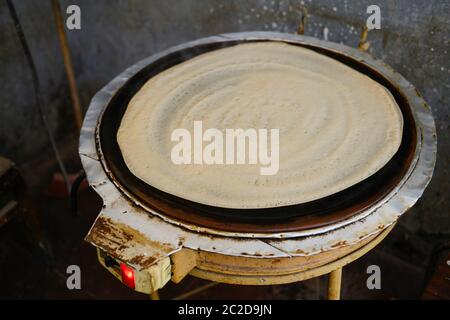ÄTHIOPIEN , Elektroofen zur Zubereitung des traditionellen Fladenbrotes injeera aus Teff-Mehl/ AETHIOPIEN, elektronisches Kochgerät zur Aufbereitung Injera Fladen aus Teig mit TEF Mehl Stockfoto