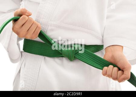 Binden eines Kimonogürtels. Nahaufnahme von den mittleren Abschnitt eines Mädchens im Kimono und band ihre Green Belt, auf weißem Hintergrund. Stockfoto