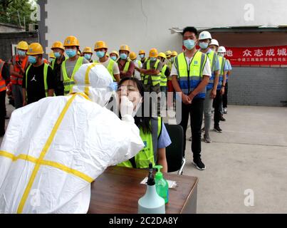 (200617) -- PEKING, 17. Juni 2020 (Xinhua) -- EIN Arzt sammelt einen Rachenabstrich von einem Bauarbeiter auf einer Baustelle im Bezirk Dongcheng in Peking, Hauptstadt von China, 17. Juni 2020. Von Juni 15 bis 17 erhielten insgesamt 1,042 Arbeiter des China Construction Third Engineering Bureau Co., Ltd (Peking) Nukleinsäuretests für COVID-19. (Foto von Ke Yuqian/Xinhua) Stockfoto