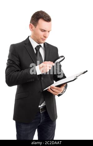 Das Porträt einer jungen Geschäftsmann auf ein Dokument auf einem Klemmbrett durch ein Vergrößerungsglas, auf weißem Hintergrund. Stockfoto