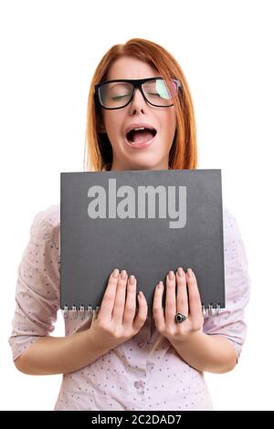 Nerdy junge Frau mit tick Gläser mit einem genervt und frustriert Ausdruck durchlöcherte einen Notebook, auf weißem Hintergrund. Stockfoto