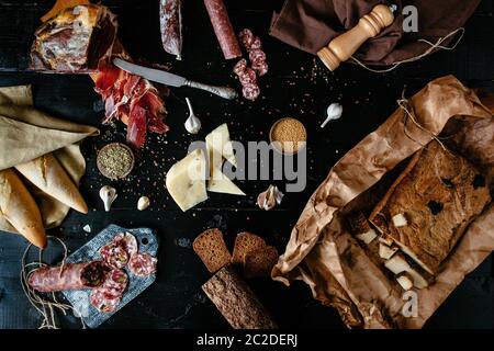 Charcuterie Konzept. Sorte Fleisch Delikatessen: Sticks von geräucherter Salami, Käse, Gewürze, Prosciutto Crudo, Brot, Speck, trocken-cured Würstchen und m Stockfoto