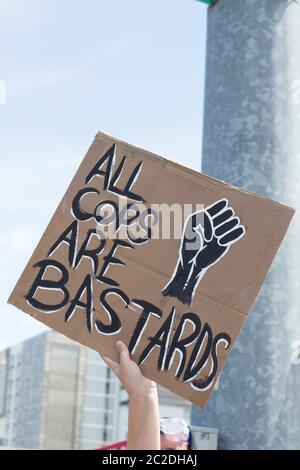 Ein Protestler bei einem Protest der Black Lives Matter, der ein Schild mit der Aufschrift "Alle Bullen sind Bastarde" hält. Stockfoto