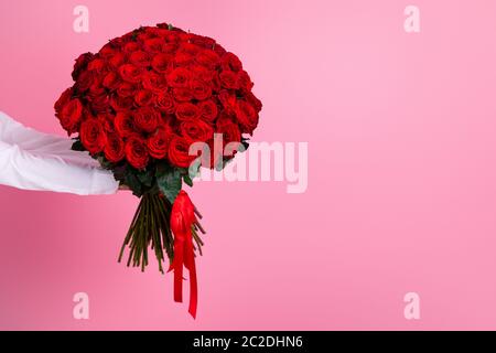 Foto von abgeschnitten Mann Arme halten große hundert rote helle Rosen Bündel geben geheime Bewunderer Lieferung Service-Arbeiter valentinstag Romantik Konzept Stockfoto