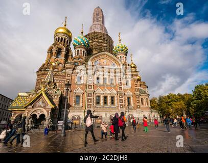 Tourist in der Kirche des Erlösers auf verschütteten Blut Fassade, St. Petersburg, Russland mit Gerüsten, die den Turm während der Renovierungsarbeiten Stockfoto