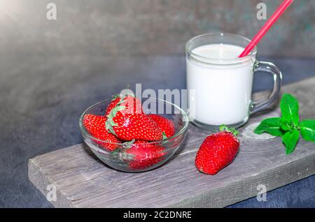 Frische Erdbeeren und Milchshake auf Holz auf Holzbrettern Stockfoto