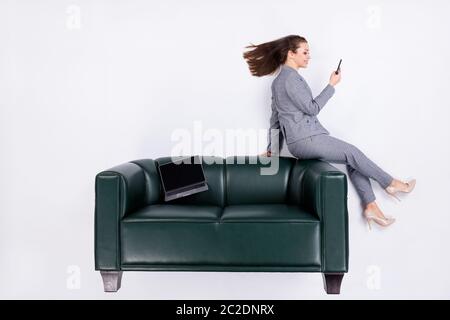 Top über hohen Winkel Ansicht vertikale Ganzkörper-Profil Seite Foto ceo Mädchen sitzen Leder Couch verwenden Smartphone Social Network Boss tragen formale High-Heels Stockfoto