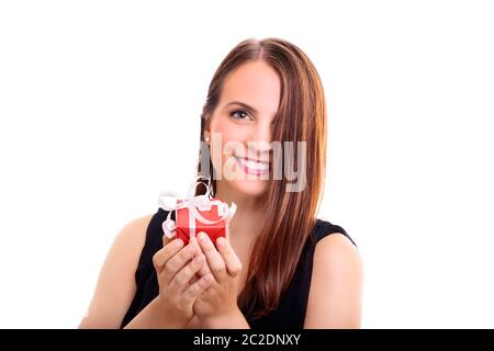 Das Portrait einer schönen lächelnden jungen Frau mit einem verpackten Geschenk, einen Eindruck sie es Ihnen, auf weißem Hintergrund. Stockfoto