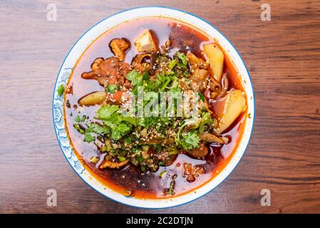 MaoCai sichuan Gericht in einer Schüssel auf einem Tisch mit zwei Reisportionen Stockfoto