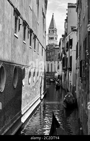 Blick auf den schmalen Seitenkanal mit Gondeln in Venedig, Italien. Schwarz-weiß venezianische Stadtlandschaft Stockfoto