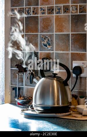 Alimium Wasserkocher gerade gekocht, Dampf steigt mit Hintergrundbeleuchtung aus einer offenen Tür, Northampton, England, Großbritannien. Stockfoto