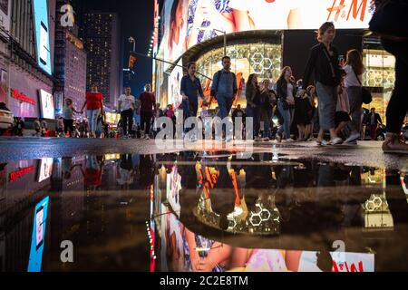 Spiegelung der regnerischen Nacht auf dem Times Square in Midtown Manhattan Stockfoto