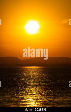 Die Sonne untergeht über Portishead und der Severn Mündung mit der walisischen Küste in der Ferne. Stockfoto